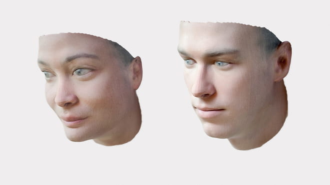 Photo of two 3D printed faces, of a woman and a man. They start at the neck and end at the top of the head, containing ears but no hair - on a white background