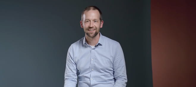Screenshot of video of man speaking to the camera and laughing. 